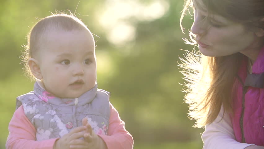 young mother looks like a baby begins to walk