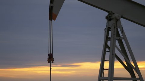 Working oil pump with sunrise in the background