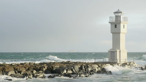 Old lighthouse at Akranes West Iceland during a storm with waves hitting the rocks
