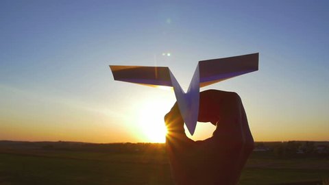 4 in 1 video! The hand hold paper airplane and launch by the bright sun and picturesque landscape background. 4x slow motion capture. Shot with Red Cinema Camera
