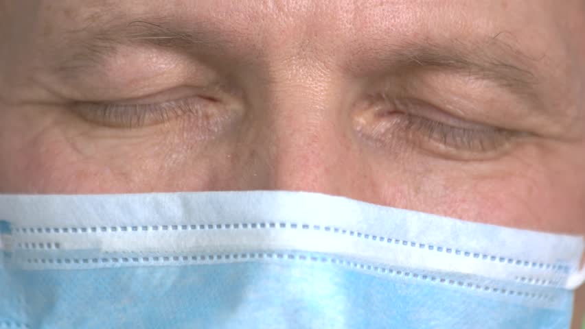 Close up doctor's closed eyes opening. Macro close up eyes blinking.