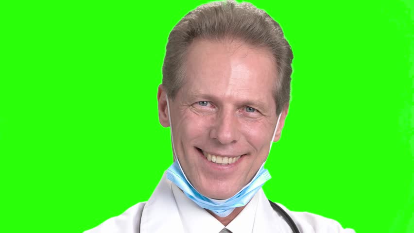 Mature smiling doctor's face. Cheerful doctor in green hroma background.