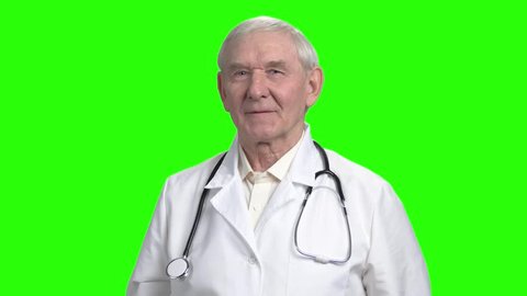 Pointing at the can of pills. Cheerful doctor advices you to take pills, green chromakey background.