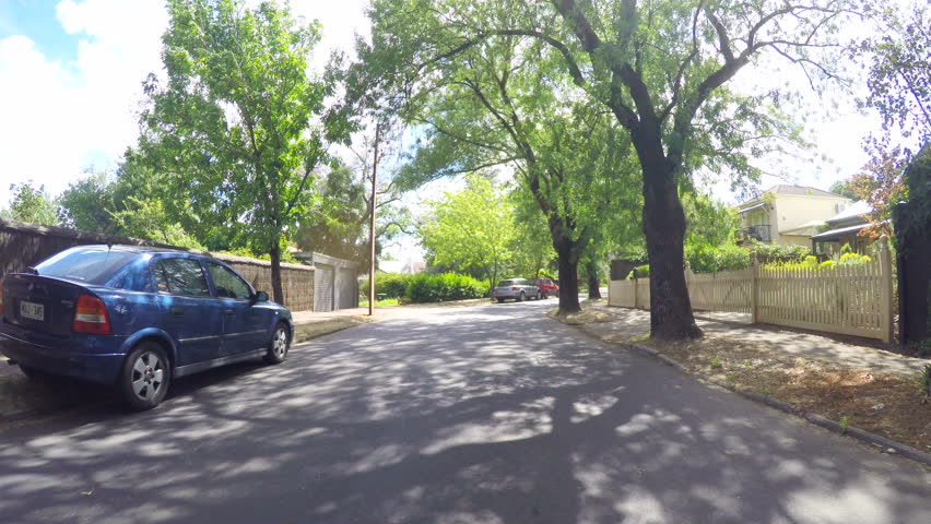 Vehicle POV driving along beautiful canopy tree lined streets, taken in Glenunga, Adelaide, South Australia, lens flare through trees.
