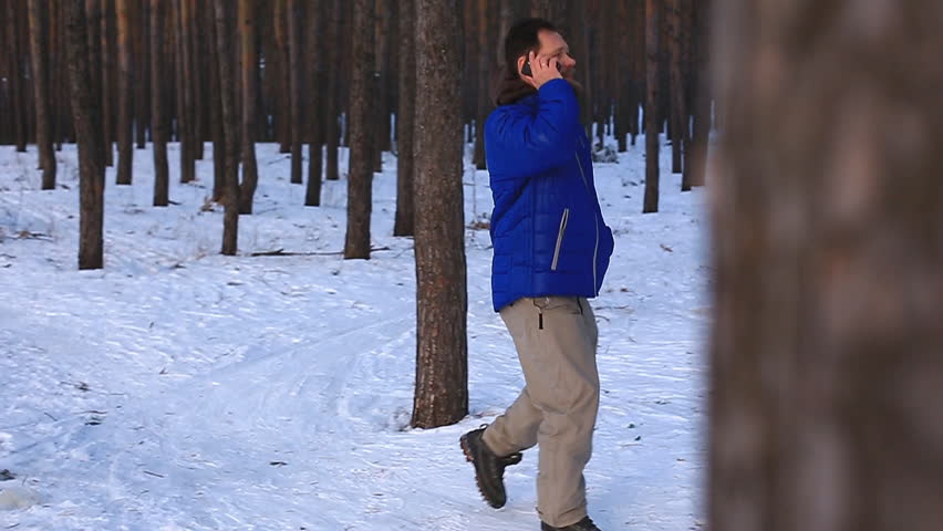 bearded man talking on the phone after training and walking in the park on a winter day
