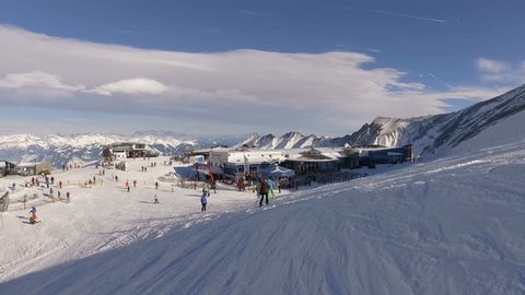 Kaprun, Austria, January 2018: Ski resort on the Kitzsteinhorn glacier with snow-covered slopes in winter. Skiers and snowboarders ride on the prepared routes in the mountains. European Alps