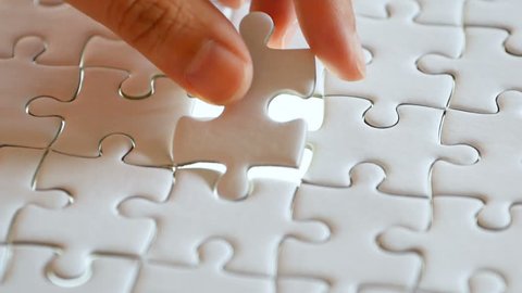 last piece of white plain jigsaw filling by hand, step of success concept