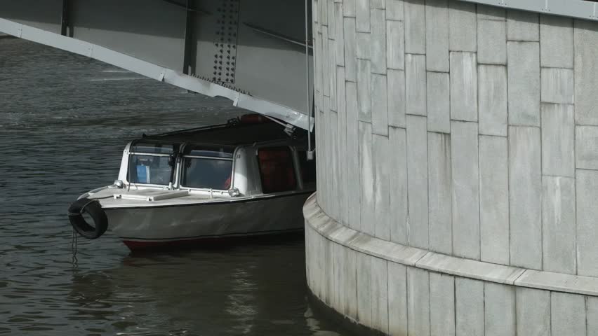 A boat docked under a bridge