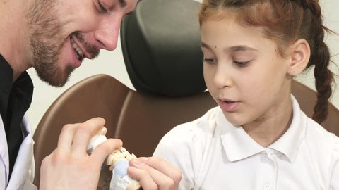 An interesting doctor tells a curious girl about the structure of the jaw