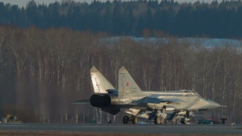 Military supersonic interceptor aircraft the MIG-31 (Foxhound). Russian Air Force. Preparing for takeoff. Warming up the engine. The same second fighter plane rides on the background.