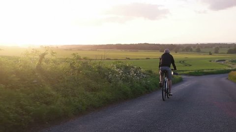 Healthy man cycling road bicycle outdoors fitness   with the sunset 