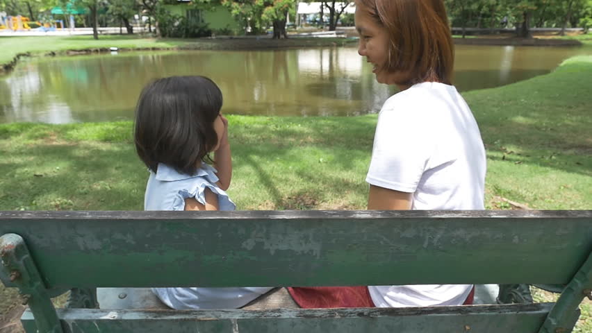 Family moment, little Asian girl playing with mother together in the park