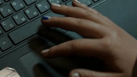 Woman hands typing on a laptop keyboard, close-up