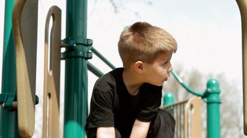 Boy at top of slide in playground