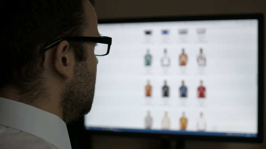 A man looks at the goods in the online clothing store, sitting at the desk. Computer online shopping . PC monitor showing blur feed page . | Shutterstock HD Video #1006582483