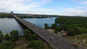 Aerial video at daytime with view of city bridge, forest and river
