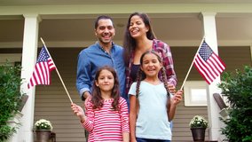 Portrait Of Family Outside House Holding American Flags - Powered by Shutterstock - Get 15% off with code: PIKWIZARD15
