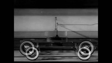 CIRCA - 1938 - Shock absorbers are used in an apparatus with model wheels in a study of bumpy movement in the suspension of a car.