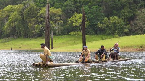 India, CIRCA 2010s - Men paddle a canoe across Lake Periyar in Kerala, India.