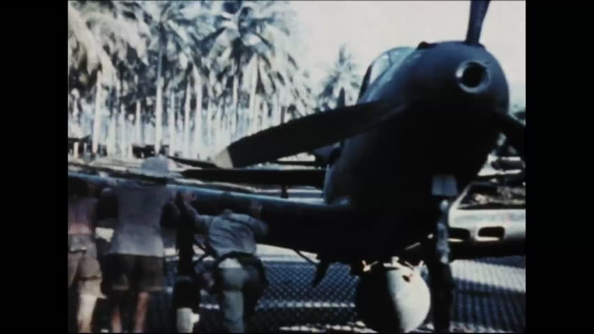 CIRCA - 1942 - An engine is installed in a Bell P-39 Airacobra warplane and pilots and G.I.s stand in a chow line Papua New Guinea in WWII.