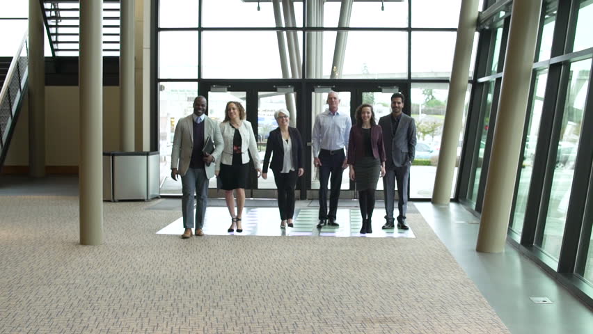Small group of people walking towards camera at a convention center Royalty-Free Stock Footage #1006606837