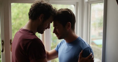 4K Loving gay male couple making up after a fight on a rainy day. Slow motion.