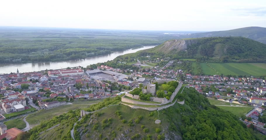 Beautiful scenery around Hainburg, Austria with the camera slowly moving down towards the fortress Schlossberg in foreground, with the Braunsberg hill and Danube river in the background.