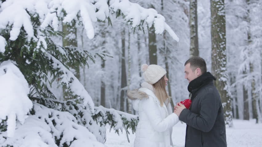 Couple laughing after snow falling on them on the date
