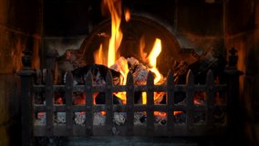 Close up 4K video clip of logs burning in a traditional fireplace.