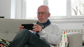 handsome mature man looking a video on his phone