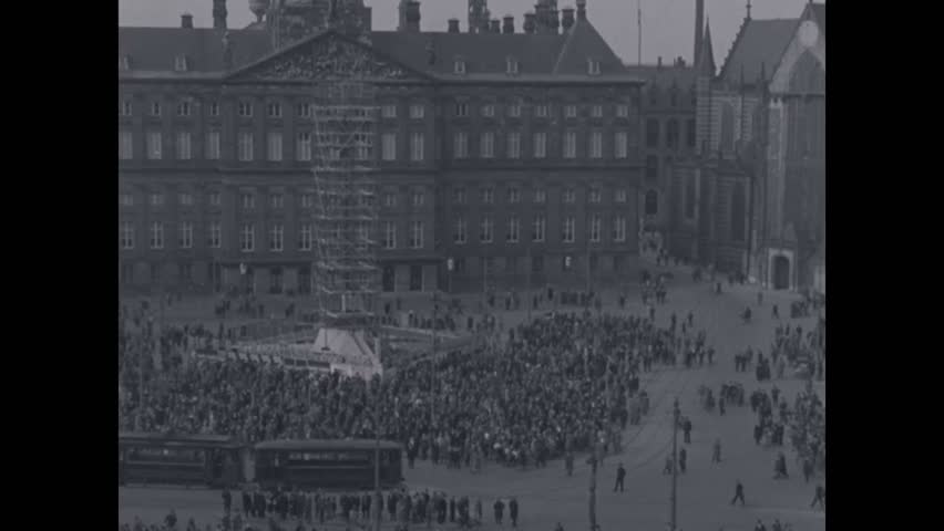 CIRCA 1920s, 1930s - People stand in town squares and on rooftops to see the Graf Zeppelin fly above the Netherlands.
