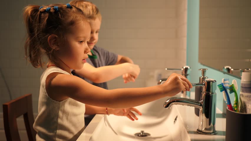 Sister and brother children in bathroom washing hands in evening family at home | Shutterstock HD Video #1006649530