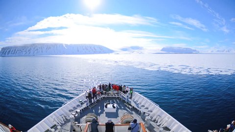CIRCA 2010s - A POV time lapse shot of a ship bow, icebergs and tourists passing through Lomfjorden near Svalbard, Norway on an icebreaker ship.