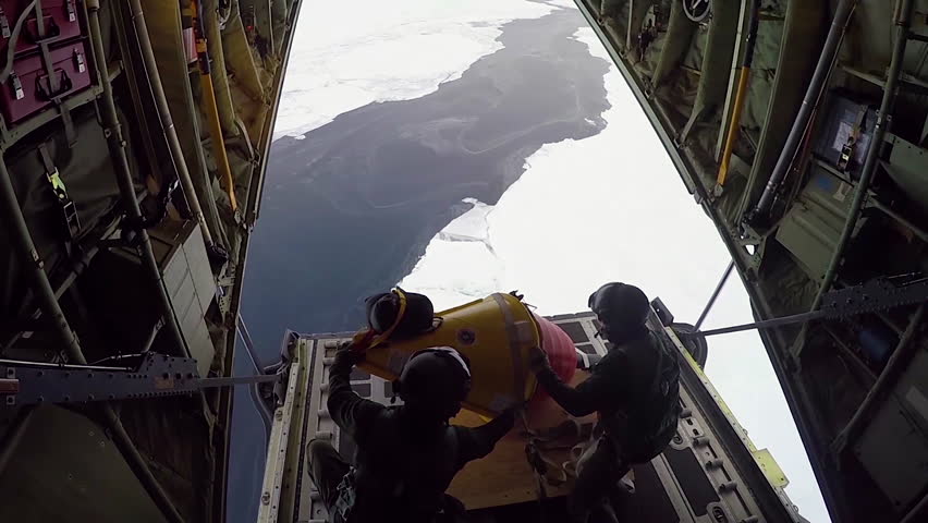 CIRCA 2010s - A buoy is dropped from a C-130 aircraft and deployed in the Arctic to measure sea ice and global warming.