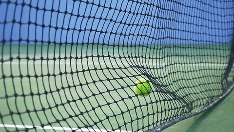 Tennis ball hits the grid falling on a tennis court in sunny day in slow motion. 1920x1080