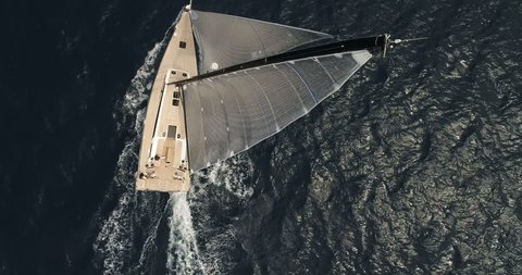 Perpendicular aerial view of a sailing boat navigating slowly