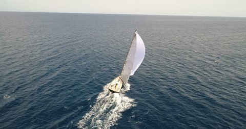 Aerial view of a sailing boat navigating with open sails