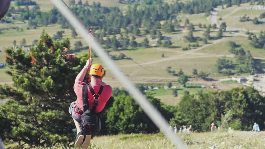 Traveling young man has an extreme vacation in high mountains, going on a rope over the mountain in slow motion. A tourist, traveler, explorer, outdoor adventure and tourism. 1920x1080