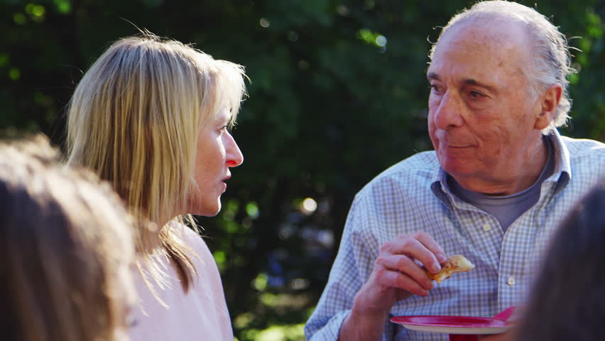 Middle aged woman and senior man talking at a block party