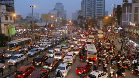 A crowded mess of motorbikes, cars and buses during rush hour at an intersection in Hanoi, Vietnam, Southeast Asia