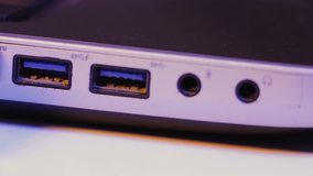 Closeup of HDMI cable plug inserted into port on the side of a laptop.