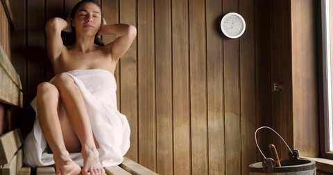 A Beautiful Woman Wearing A White Towel Takes A Sauna The Sauna Is