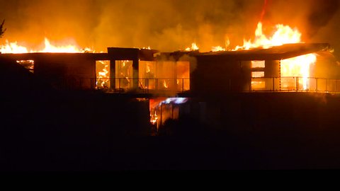 VENTURA, CALIFORNIA - CIRCA 2010s - A large home burns at night during the 2017 Thomas fire in Ventura County, California.