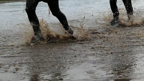 Runners In Water and Mud In Obstacle Endurance Race Slow Motion