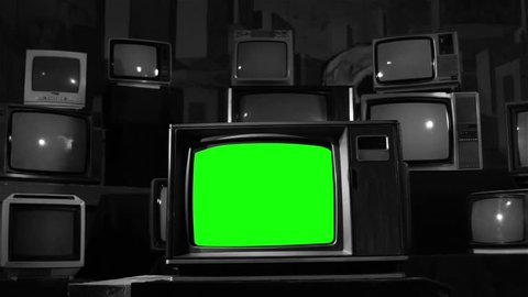 Retro TV with Green Screen over a Pile of Retro TVs. Dolly In. Black and White Tone. You can Replace Green Screen with the Footage or Picture you Want with “Keying” effect in AE (check tutorials). 