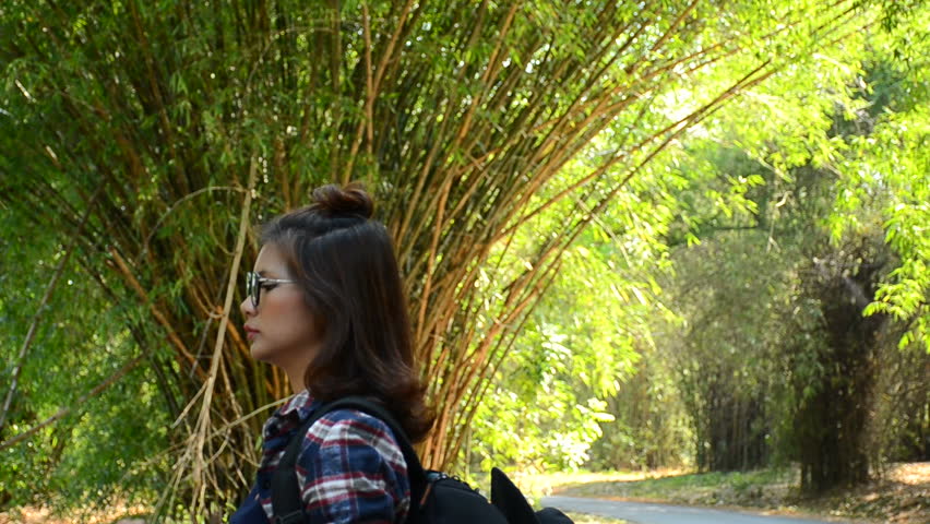 Beautiful Asian girl drinks water from a bottle outdoors