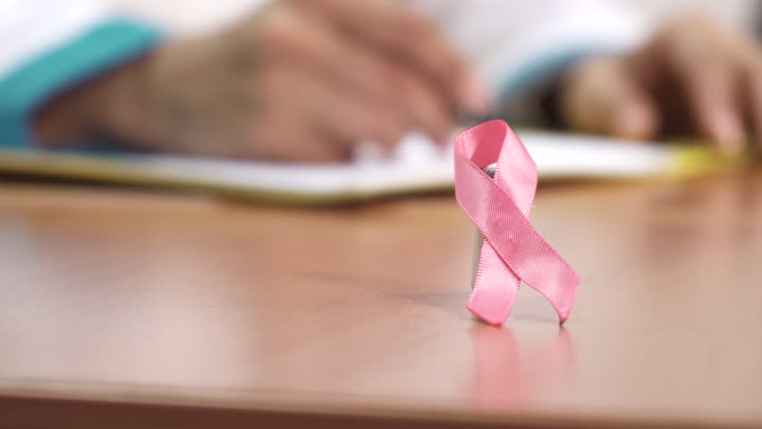 Selective focus on pink ribbon breast cancer awareness symbol doctor writing notes working at the clinic on the background copyspace profession feminine health medicine prevent. Royalty-Free Stock Footage #1006720057