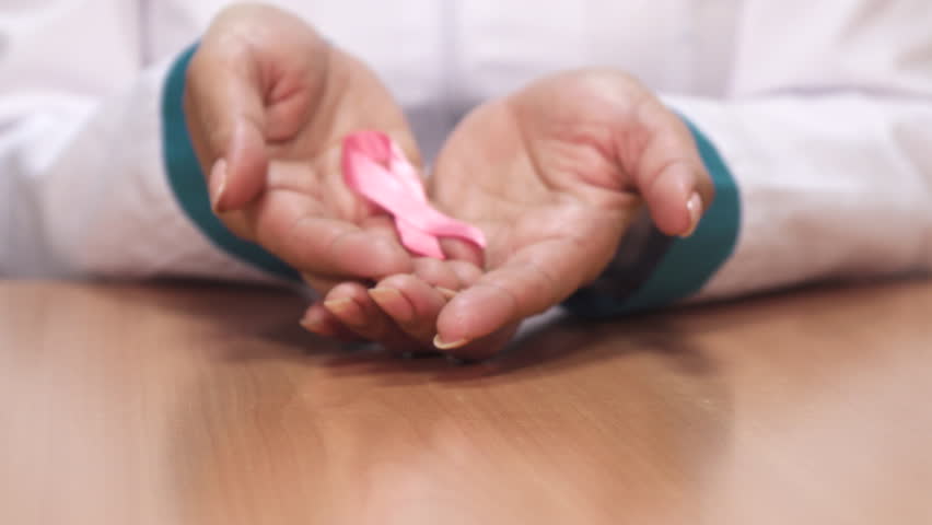 Close up of the pink ribbon breast cancer awareness symbol in the hands of a female doctor therapist health medicine hospital prevention women feminine support concept. Royalty-Free Stock Footage #1006720114