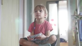 Young child girl playing video game Gamer girl with gamepad controller