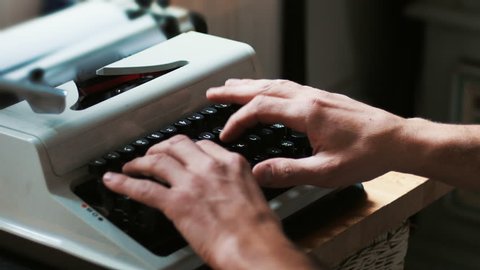 Hands typing a film script or a book on a vintage typewriter, 4k video